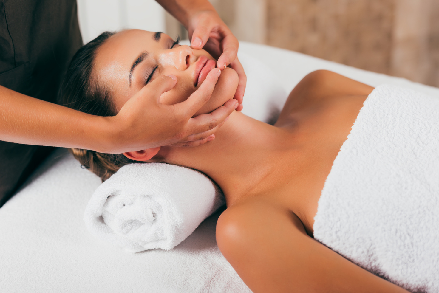 beautiful woman having face massage in spa salon
